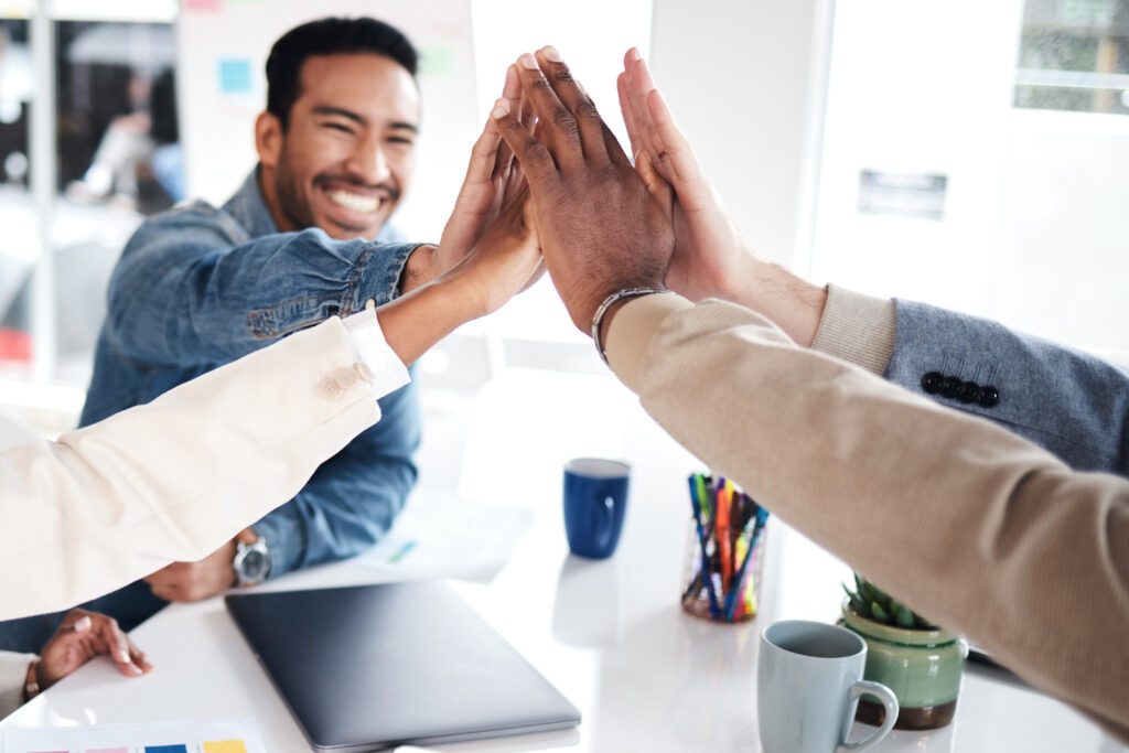 Creative people, meeting and high five for team building, success or achievement at the office. Happy group with hands together for teamwork, celebration or support in trust or startup at workplace