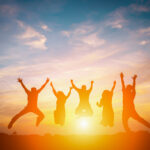 Silhouette of happy business team making high hands in sunset sky background for business teamwork concept.