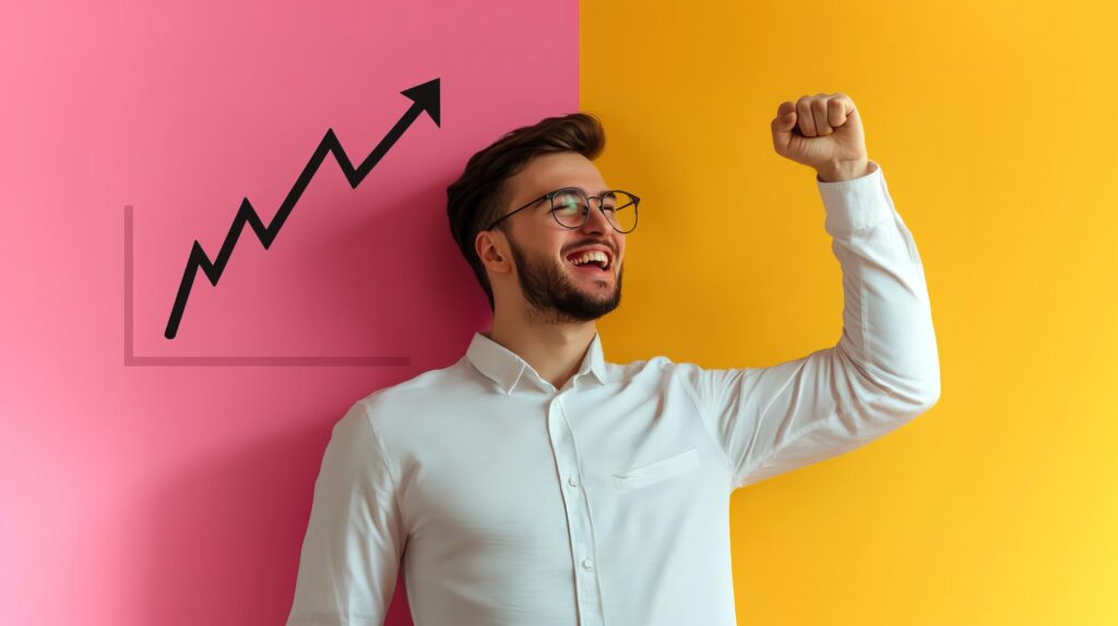 A young businessman celebrates success, raising his fist in excitement against a colorful backdrop, symbolizing growth and achievement.