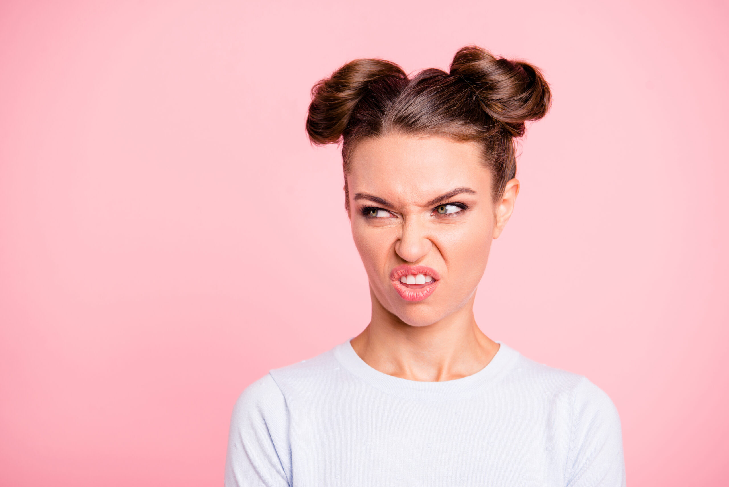 Close-up portrait of nice lovable attractive well-groomed modern angry girl looking at ugly object isolated over pink pastel background